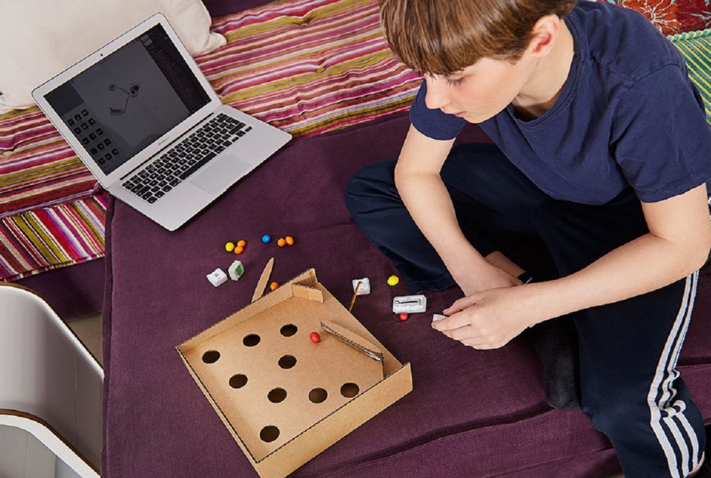 Kid-playing-with-SAM-pinball-machine